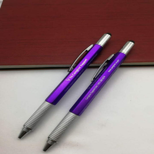 Twee paarse Altijd handig bij de hand: 6-in-1 multifunctionele pennen met zilveren accenten op een houten oppervlak.