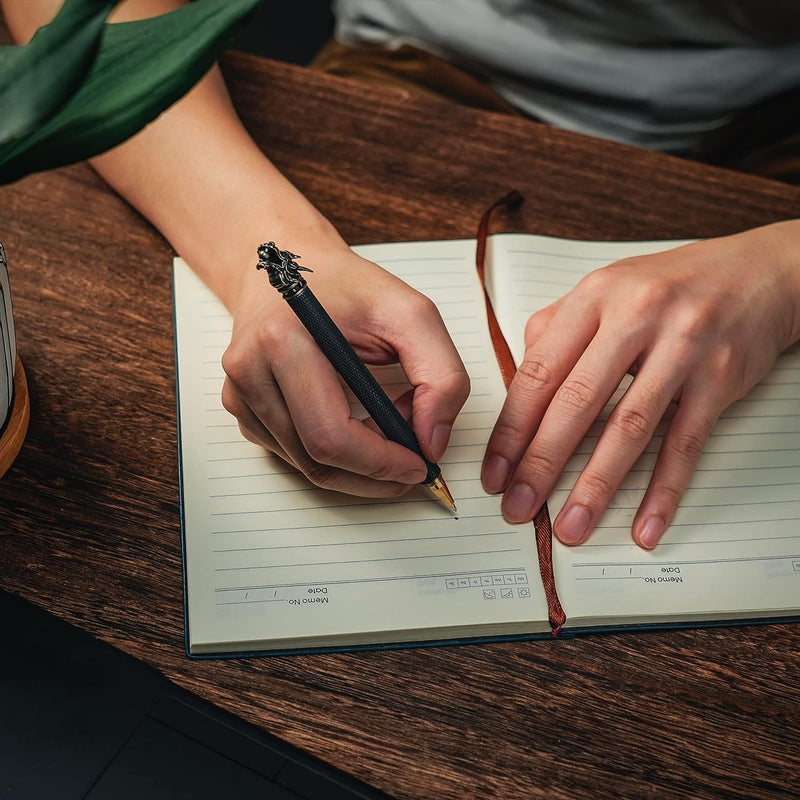 Laad afbeelding in Galerijviewer, Een persoon die in een notitieboekje schrijft met een Uw stijlvolle metgezel voor alledaagse avonturen pen.
