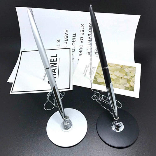 Twee elegante Perfect Service pennen van zilver met kettingbevestigingen, een op een witte standaard en een op een zwarte standaard, gebouwd.