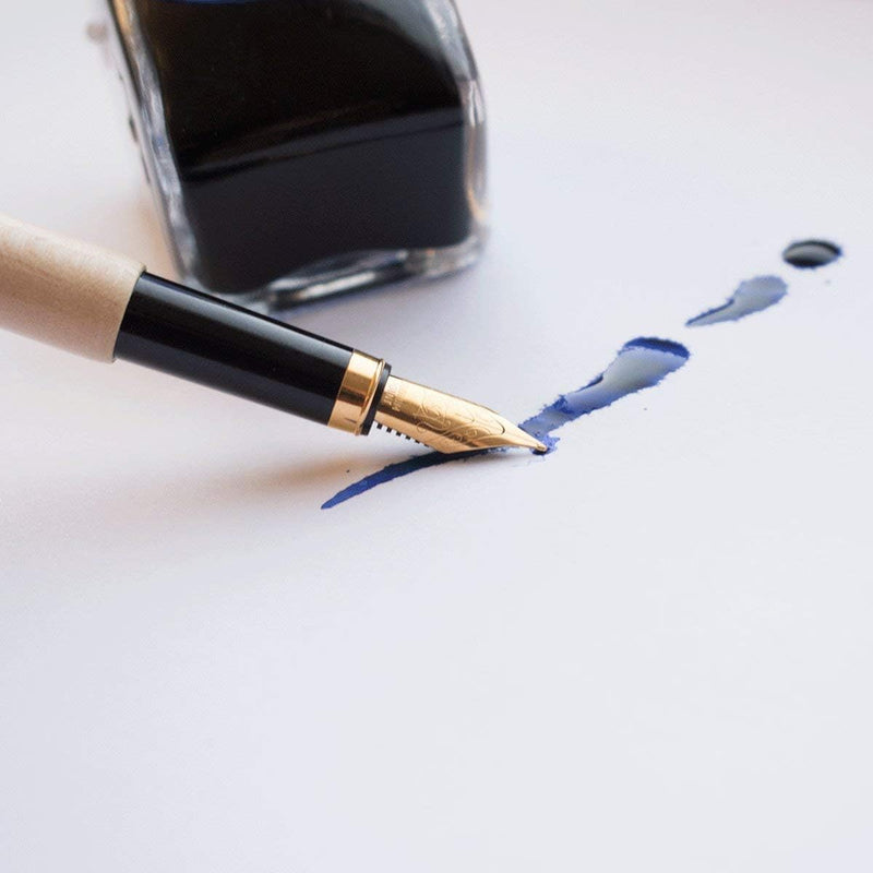 Laad afbeelding in Galerijviewer, Een elegant schrijfcomfort met een duurzaam tintje van esdoornhout met blauwe inkt nabij een inktfles op een witte achtergrond.
