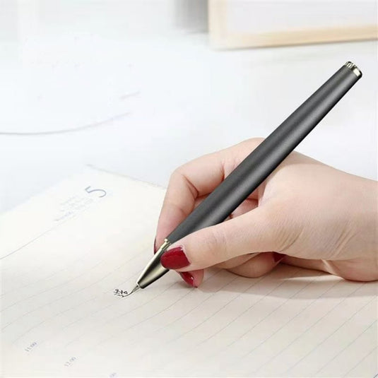 Een persoon die op een notitieblok met rasterlijnen schrijft met een zwarte pen die op de Houd uw bureau netjes met de magnetische pen standaard is geplaatst.