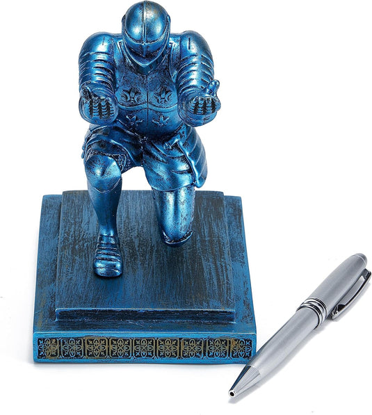 Blauw metallic Knielende ridder pennenhouder in een lopende pose naast een zilveren pen op een witte achtergrond.