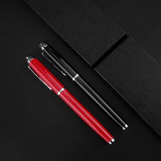 Twee Laat een blijvende indruk achter met deze elegante en hoogwaardige rollerbalpennen naast een in leer gebonden notitieboekje op een zwart oppervlak.