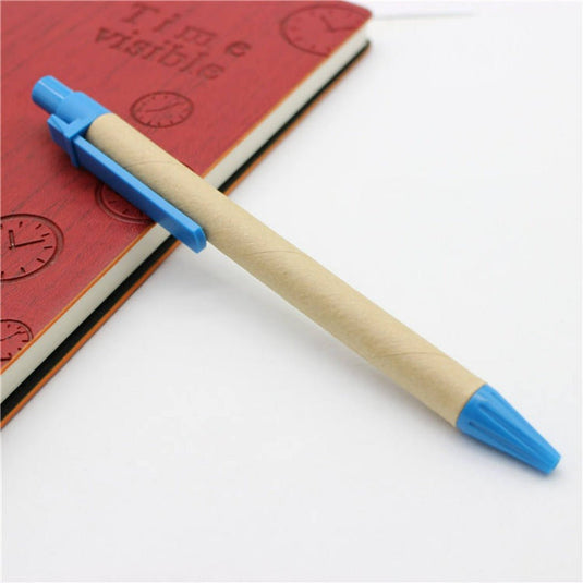 Een houten pen met blauwe accenten en hoogwaardige inkt rustend op een gesloten notitieboekje met rode stempels.
Maak een milieuvriendelijke keuze met onze set van 12 milieuvriendelijke balpennen rustend op een gesloten notitieboekje met rode stempels.