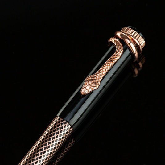 Een elegante zwarte metalen slangenbalpen met sierlijke koperen details, weergegeven tegen een zwarte achtergrond.