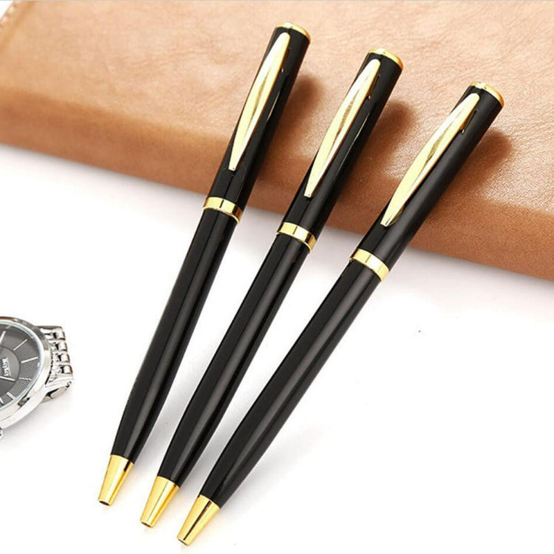 Laad afbeelding in Galerijviewer, Drie zwarte en gouden pennen geplaatst op een bureau bij een polshorloge, waaronder onze Eco-vriendelijke duurzame metalen pen gemaakt van gerecyclede materialen.
