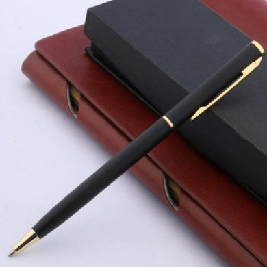Zin met productnaam: Een betaalbare Ontdek de tijdloze elegantie van klassieke balpennen met gouden accenten rustend op een gesloten bordeauxrood dagboek.