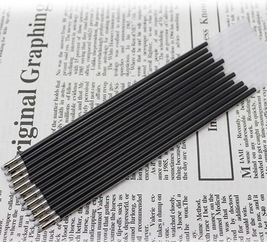 Een bundel Ontketen systematisch schrijfplezier: balpen vullingen in zwart en blauw - set van 12 stuks met rijke kleuren bovenop een krant.