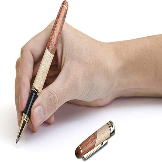 Een hand die een Schrijf in stijl vasthoudt: De handgemaakte houten gelinkte pen cadeauset voor een schrijfervaring met een dop ernaast geplaatst op een witte achtergrond.