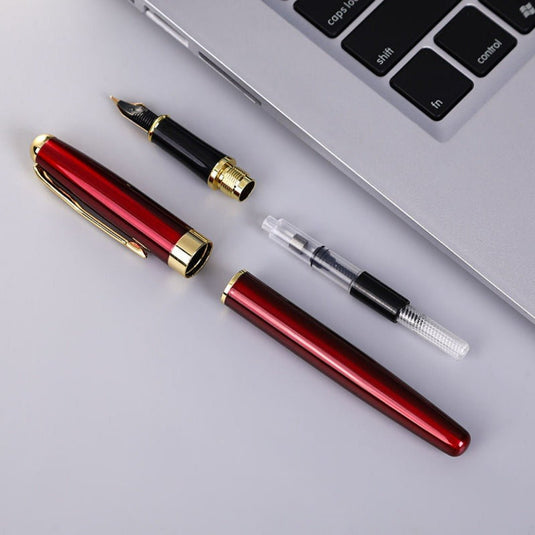 Schrijf in stijl met de metalen Uniball vulpen, gedemonteerd tot zijn componenten, ligt naast een laptop.