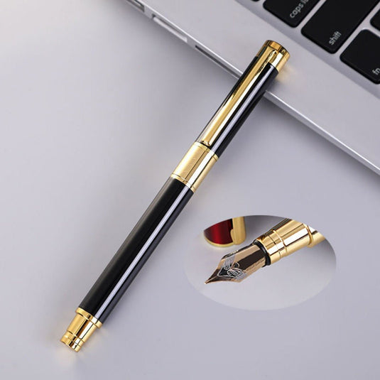 Een luxe zwarte en gouden Schrijf in stijl met onze luxueuze marmeren vulpen met iridium punt, ligt op een bureau naast een laptop, met de dop verwijderd om de nib te begrijpen.