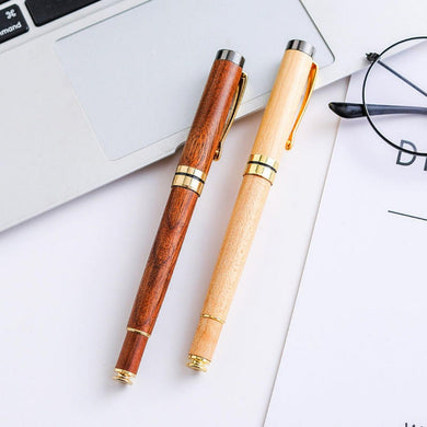 Twee elegante Stijlvolle en functionele houtnerf zakelijke balpennen naast een laptop en een bril op een wit oppervlak.