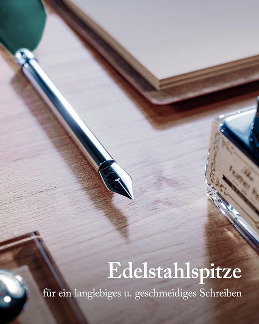 Verleidelijke pennenset: Ontdek de magie van kalligrafie met een roestvrijstalen penpunt op een bureau naast een inktpot en een gesloten boek, deel uitmakend van de set.