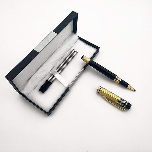 Een pennenset met een Verleidelijke rollerball en een balpen, liggend naast een open cadeauverpakking op een wit oppervlak.